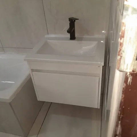 Wall-mounted vanity sink with matte black tap, finished bathroom